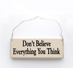 wood sign saying Don't Believe Everything You Think