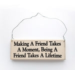 wood sign saying Making a Friend Takes a Moment, Being a Friend Takes a Lifetime