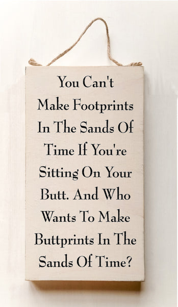 wood sign saying You Can't Make Footprints In The Sands Of Time If You're Sitting On Your Butt. And Who Wants To Make Buttprints In The Sand Of Time?