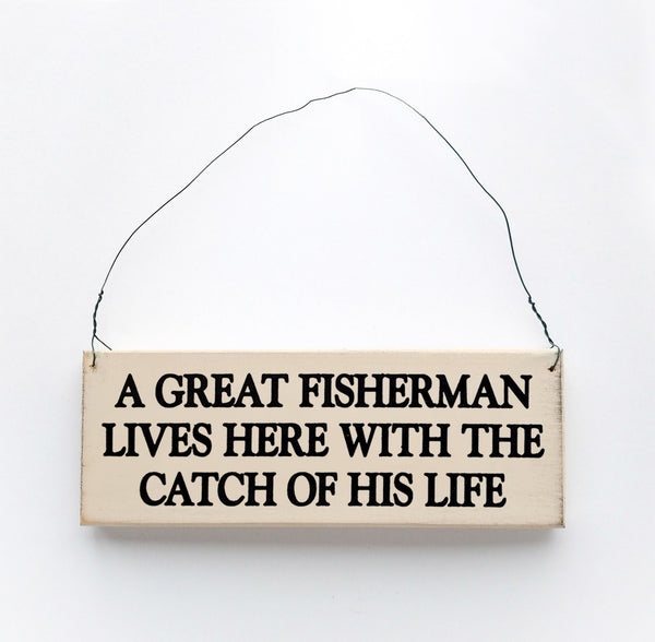 wood sign saying A Great Fisherman Lives Here With The Catch of His Life