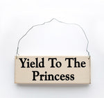 wood sign saying Yield to the Princess
