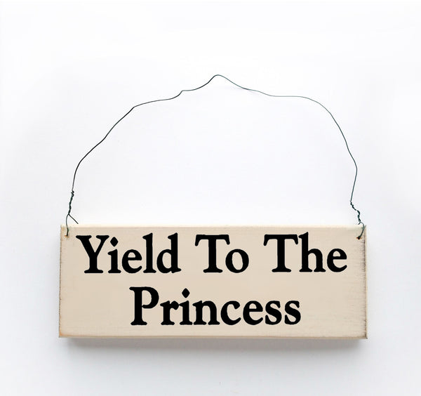 wood sign saying Yield to the Princess