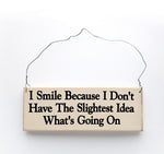wood sign saying I Smile Because I Don't Have the Slightest Idea What's Going On