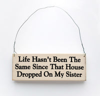 wood sign saying Life Hasn't Been the Same Since That House Dropped On My Sister