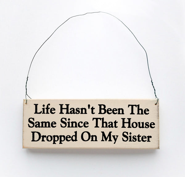 wood sign saying Life Hasn't Been the Same Since That House Dropped On My Sister