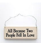 wood sign saying All Because Two People Fell In Love