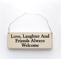 wood sign saying Love, Laughter and Friends Always Welcome