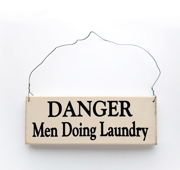 wood sign saying Danger Men Doing Laundry