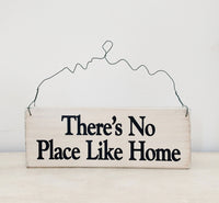 wood sign saying There's No Place Like Home