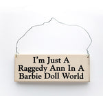 wood sign saying I'm Just A Raggedy Ann In A Barbie Doll World