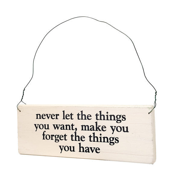 wood sign saying Never Let The Things You Want, Make You Forget The Things You Have